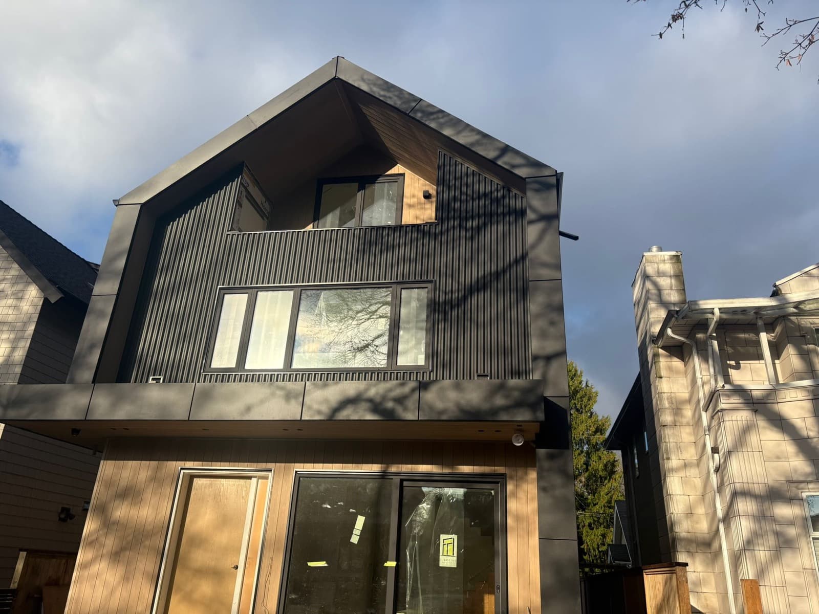 Completed dark metal panel siding exterior